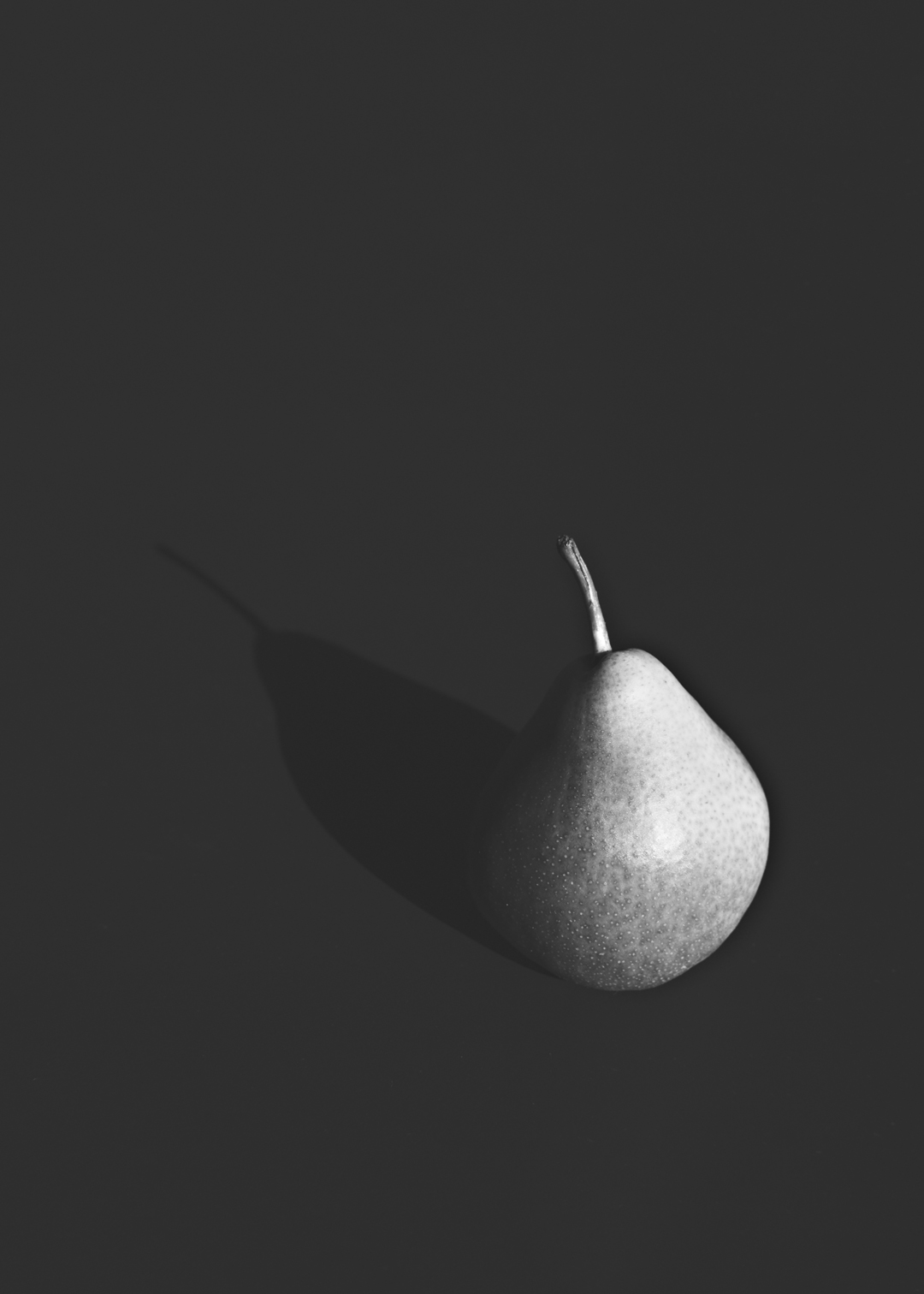 Pear with shadow on dark by michelle p. via besotted